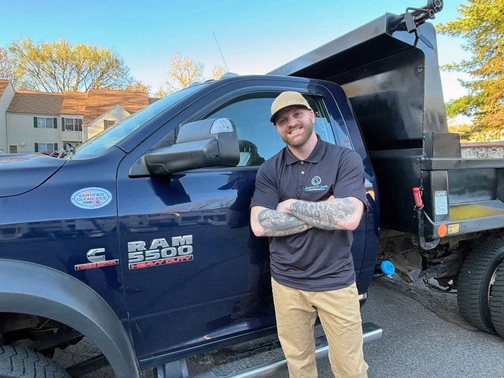 Professional septic contractor standing beside service truck